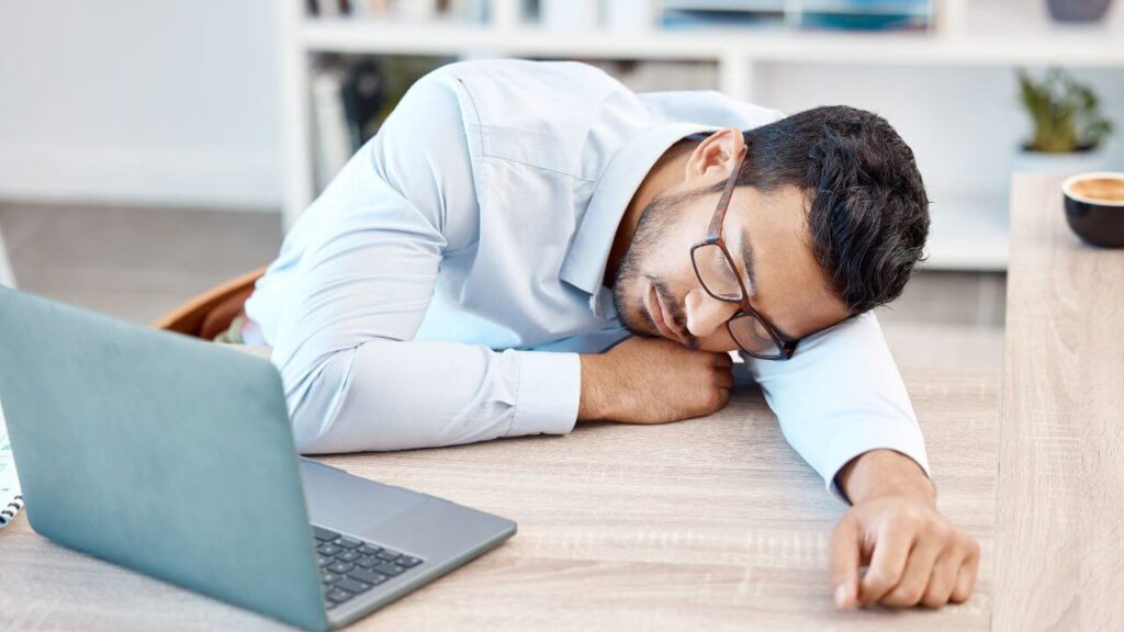 A man feels fatigue at his desk